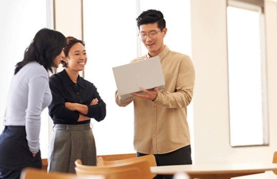 ノートパソコンの画面を 2 人の女性と共有している男性