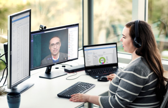 自宅からリモートで働き、Microsoft Teams、Word、Excelを実行している女性企業従業員。