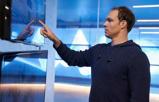 大型タッチパネルを指差す男性