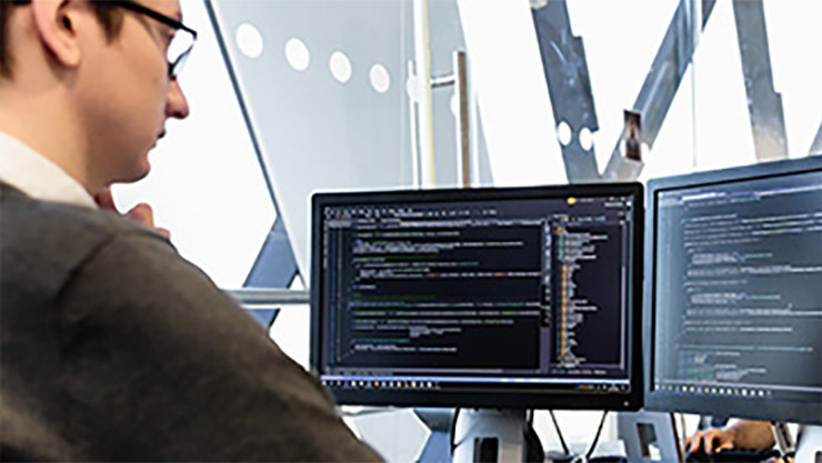 2台のディスプレイでPCを操作する男性