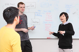 会議室で話し合う 3 人