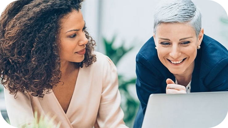 ノートパソコンの画面を見る2人の女性。