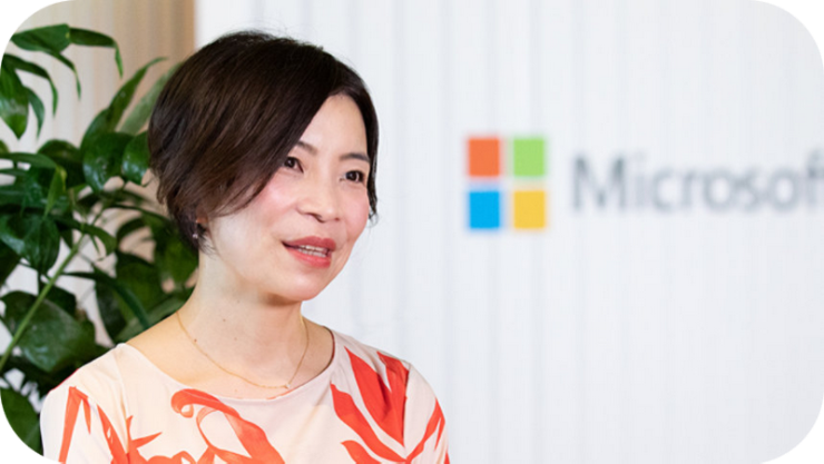 マイクロソフトのロゴを背景にしたノリエのポートレート。