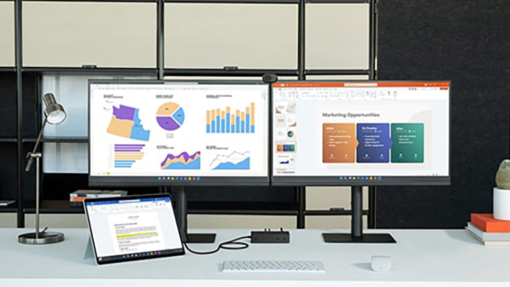 図やチャートが表示された 2 つのディスプレイと Surface Pro