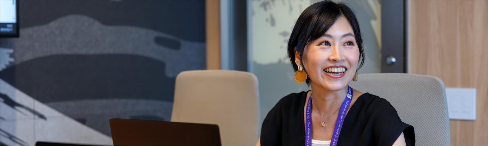 グレーの模様がある壁の室内でMadokaが笑顔な様子