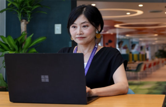 カフェテリアでMadokaがパソコンに向かって作業している