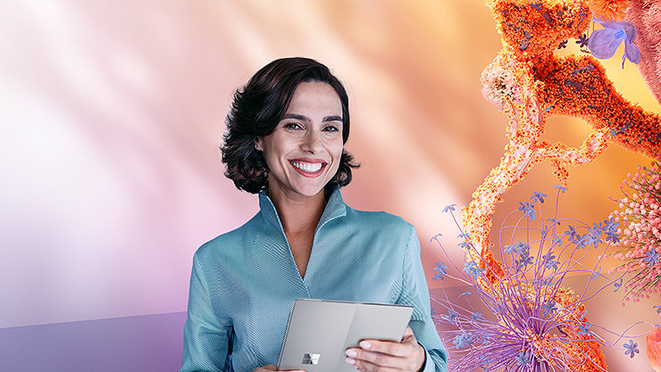 Smiling woman holding a tablet and standing in front of an lilac background with abstract, colorful shapes