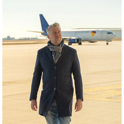 In the picture, the changemaker Patrick Marous is standing in front of an Airbus.