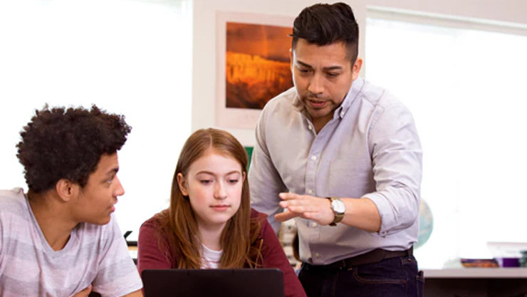 パソコンを見て、ディスカッションをしている三人