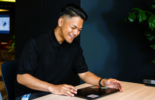 観葉植物が置いてある黒い壁紙の社内で座っているMauricio