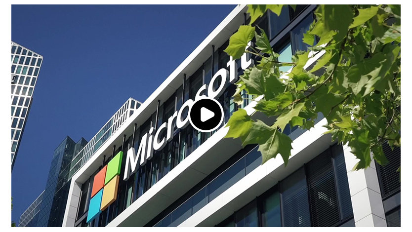 Bürogebäude mit Microsoft Logo, im Hintergrund blauer Himmel