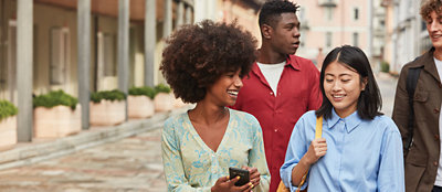 数人の男女が屋外で話しながら楽しそうに歩いている