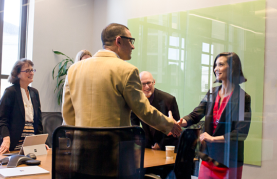 ミーティング ルームで握手をするビジネス パーソン