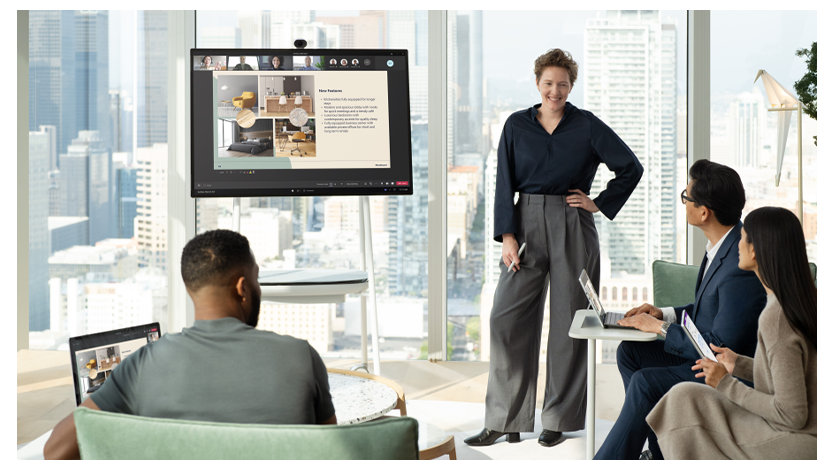 Surface Hub を使用して他の 3 人にプレゼンテーションを行うビジネスパーソン