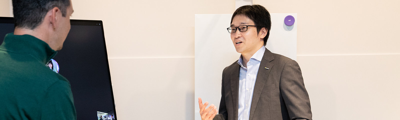 他の社員と話をする Takayasu さん