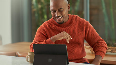 Surface のラップトップで仮想会議に参加するビジネスパーソン