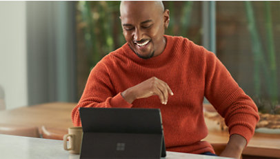 Surface のラップトップで仮想会議に参加するビジネスパーソン