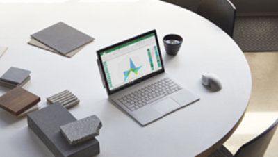 ラップトップは、他の文房具と一緒に白い丸テーブルの上に置かれます