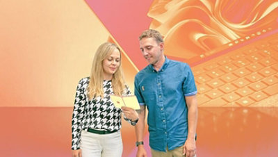 Frau und Mann betrachten eine Karte vor abstraktem, orangefarbenem Hintergrund, der einen Laptop darstellt.