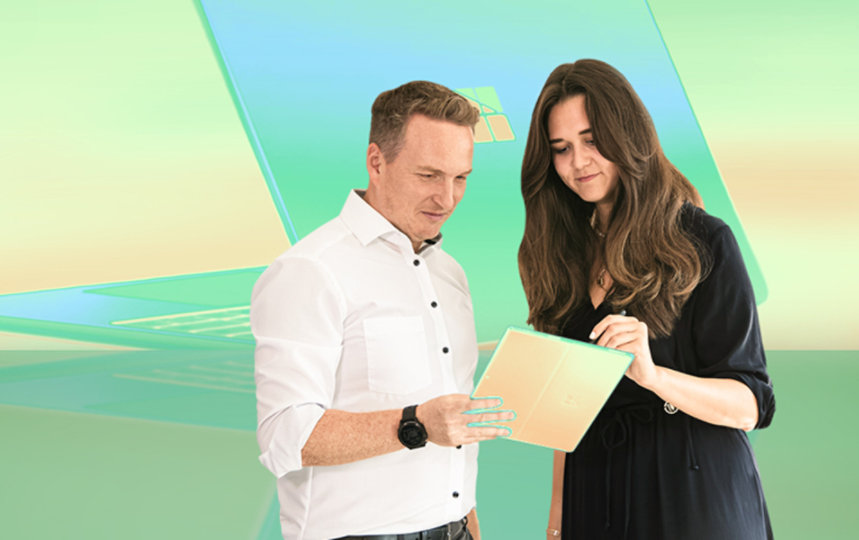 Zwei Geschäftsleute betrachten ein Dokument vor einem blauen und grünen Hintergrund mit Windows-Logo.