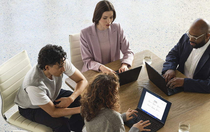 A Lenovo device being used by a mixed-gender team in an office space.
