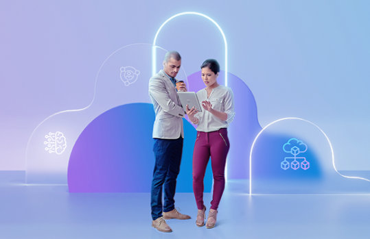 Eine Frau und ein Mannschauen gemeinsam auf einen Laptop, sie stehen vor violettem Hintergrund