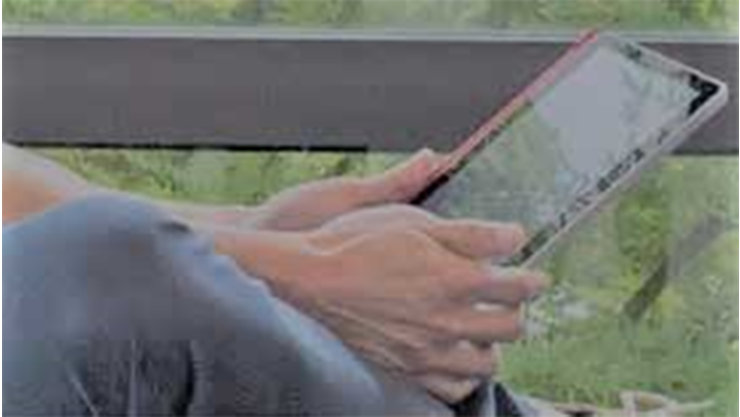 公園でタブレットを操作する男性