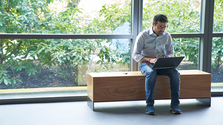ベンチで PCを操作する男性