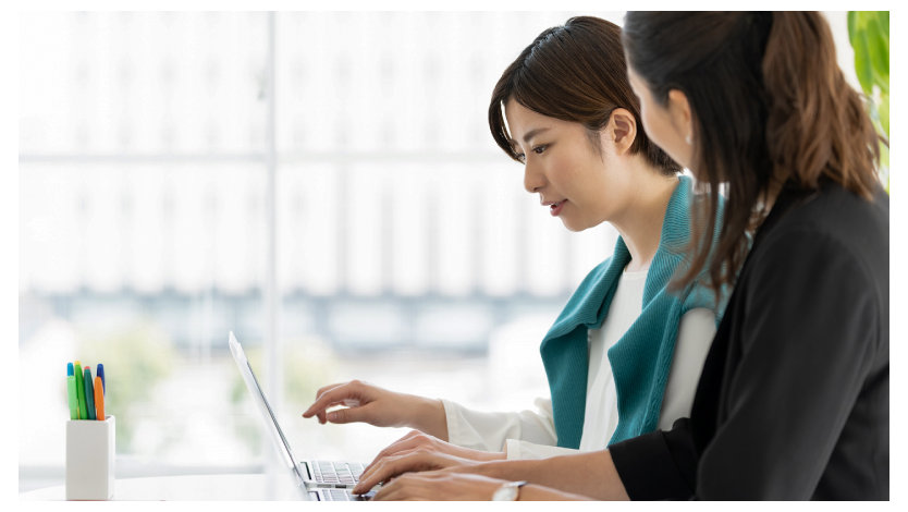 レクチャーを受けながらノート PC を操作する女性