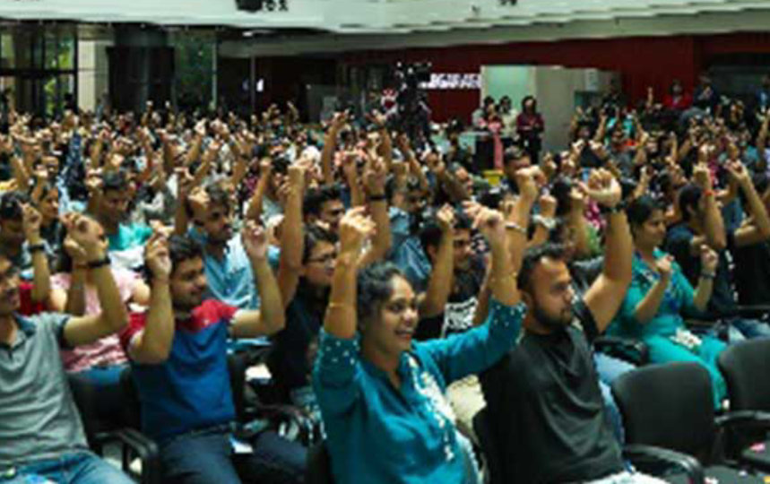 crowd raising hands in an audotorium