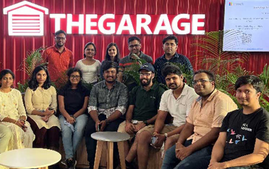 guys posing for camera with red-background-wall and TheGarage Logo and Text