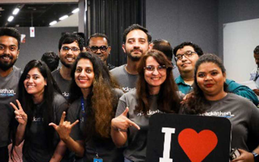 guys posing with hands up displaying banner