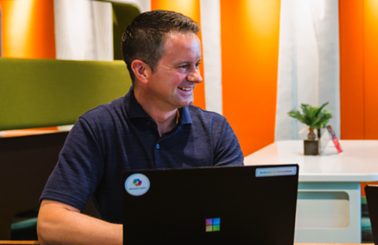 パソコンを前に置いた状態で座っているJason