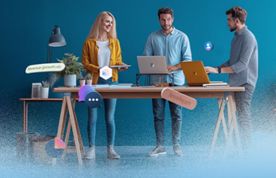 Drei Personen arbeiten gemeinsam an einem Schreibtisch mit. Verschiedene digitale Symbole schweben um sie herum.