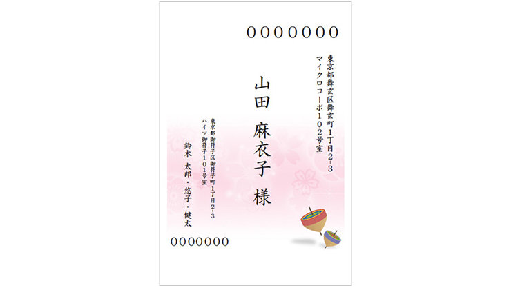 氏名と住所が日本語で書かれ、2つのカラフルなコマで飾られた日本の挨拶状。