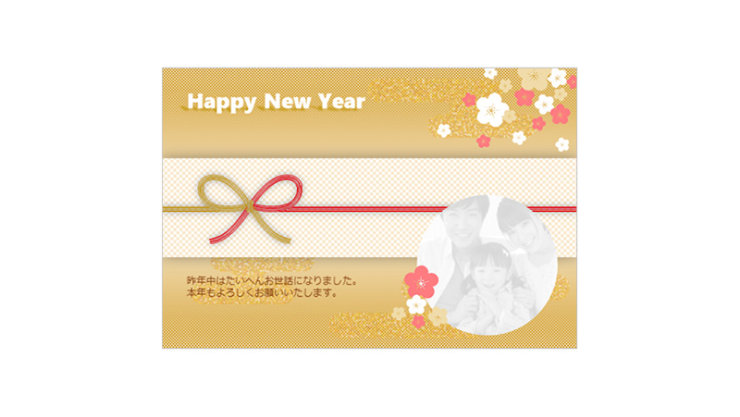 金色の背景に「Happy New Year」の文字と花、水引の装飾が施された横長の年賀状デザイン。丸い写真フレームと日本語の挨拶文も含まれる。
