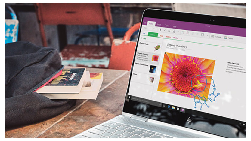 OneNote画面と本の入ったバッグを備えたラップトップ