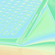 緑と青の抽象的な効果を備えたラップトップ キーボードのクローズ アップ