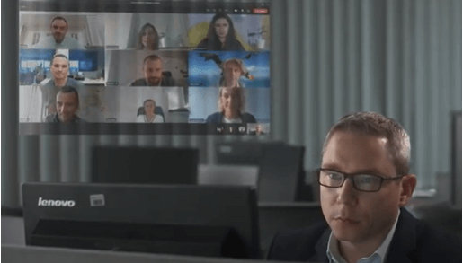 Mężczyzna patrzy w monitor laptopa, z boku widać zrzut z jego ekranu, a na nim osoby biorące udział w spotkaniu na Teams.