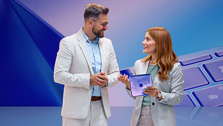 Ein Mann und eine Frau unterhalten sich, die Frau hält ein Tablet. Im Hintergrund ist eine Tastatur zu sehen.