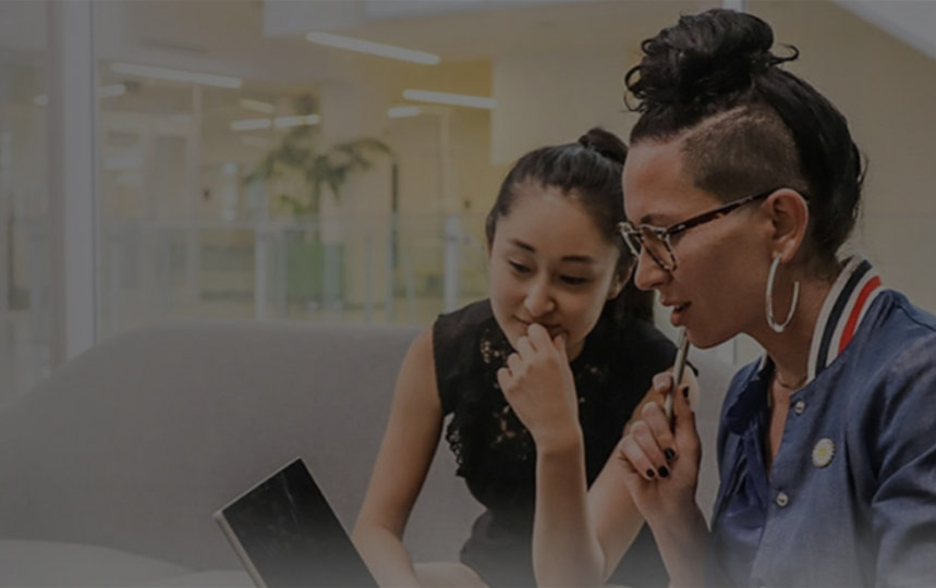 Two females employee in looking at the screen of the Surface product