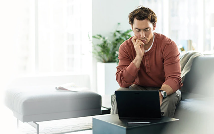 A man looking at a device whilst seated down