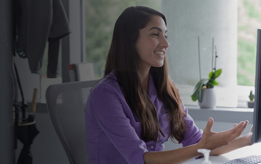 A female employee speaking in a virtual meeting in the office