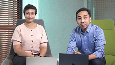 Two colleagues are sitting on chairs with their laptops in front of them