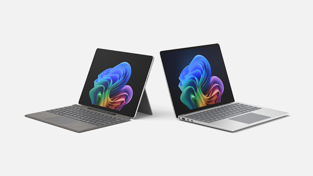 Windows 11の画面を表示した、シルバーのSurface ProとSurfaceノートPCが並ぶ様子。
