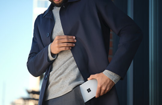 Surface Duo 2 を服のポケットに入れようとしている人