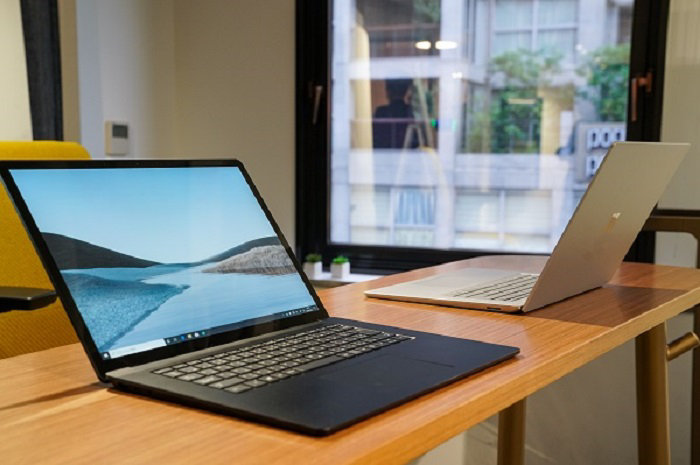 2 台の Surface ラップトップが窓の近くのテーブルに置かれています