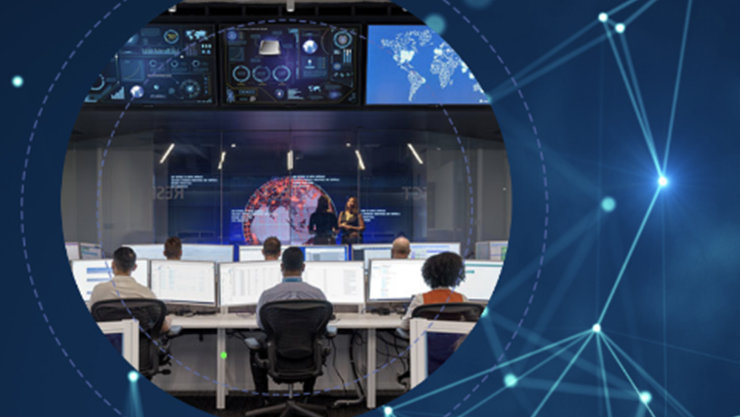 People sitting in front of rows of computers and digital maps