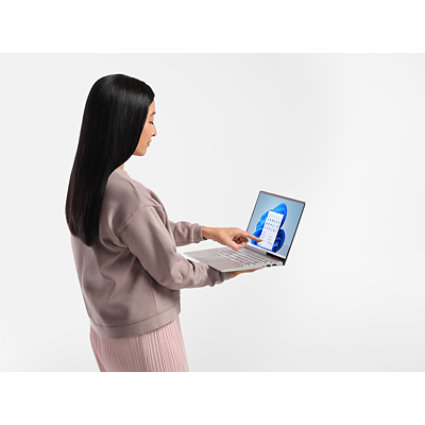 机の上のシルバーのノートパソコンで、音楽ストリーミングサービスが開いています。