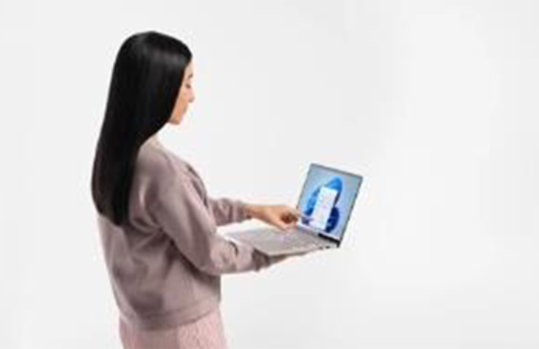 女性が手の上にパソコンを置いて、指で画面を指している